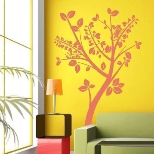 Stylish tree in pastel shades on a yellow wall in a modern living room, creating a cozy atmosphere.