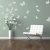 Butterfly sticker set 1127 - Decor in a green living room with white butterflies on the wall and a white chair.