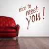 Sticker 03X 16 nice to meet you 1741 - Living room setup. Red sofa against a white wall with text.