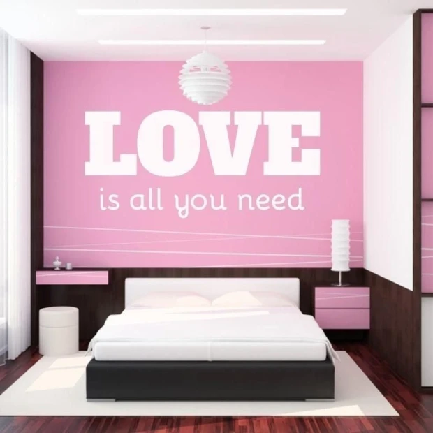 Sticker 03X 24 love is all you need 1723 - Bedroom decor with pink walls and white and black furniture.