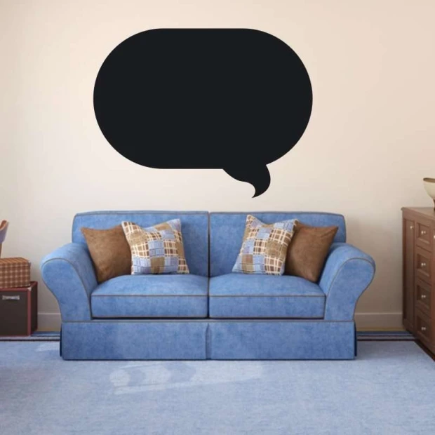 Chalk sticker speech bubble 175 - Living room setup with light walls and a blue sofa with checkered cushions.