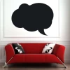 Chalk sticker speech bubble 177 - Living room setup. Light-colored walls, red sofa with black and white patterned cushions.