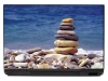 Laptop sticker beach P265 - Graphic design. Stacked stones on the beach with the sea in the background.
