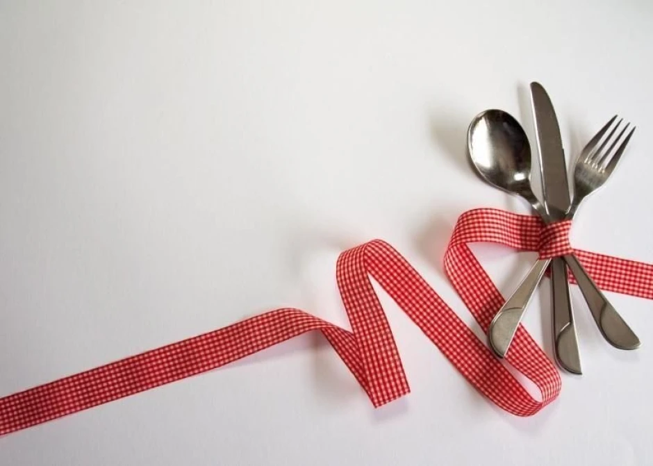 Dry-erase board with 209 cutlery pieces - Graphic design. Cutlery arranged on a white background, wrapped in a red checkered ribbon.