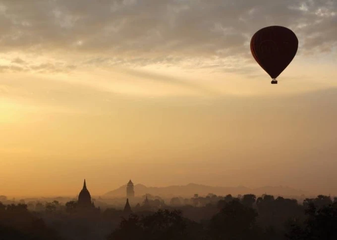 Dry-erase board balloon 233 - Graphic design. Red balloon against a gray sky and dark building silhouettes.