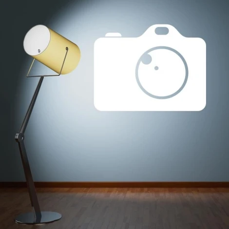 Camera-shaped whiteboard 198 - Styled in a blue-walled room with wooden flooring.