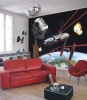 Star Wars Millennium Falcon wallpaper in a living room with a red sofa, white walls, and a dark table.