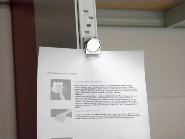 Metal magnetic clip - Office setup with light-colored walls, documents, and instructions on the desk.