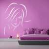 Decorative sticker of a woman\'s face 2033 - Bedroom decor with pink walls and a bed featuring a gray headboard.