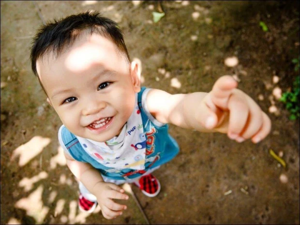 Custom large wall sticker - Graphic design. Child in a blue shirt smiling and pointing upwards.