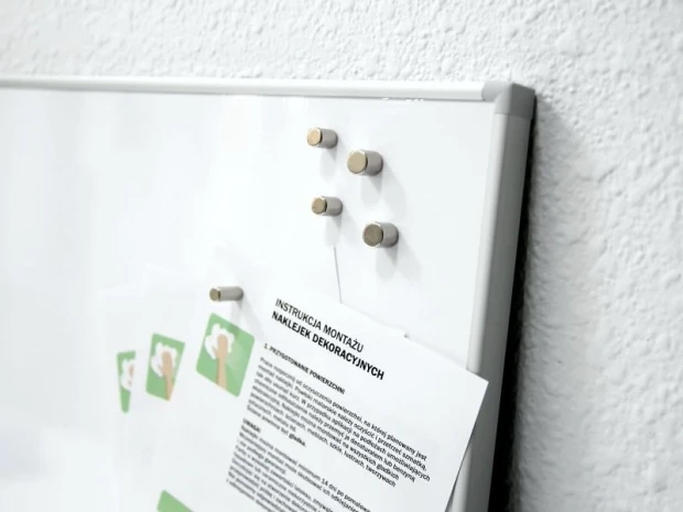 Set of 5 neodymium magnets in various sizes - Office setup with light-colored walls and a simple magnetic board.