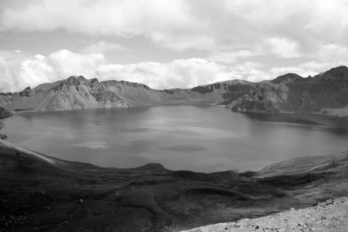 Wall mural Pektu-san FP 1575 - Graphic design of a mountain lake surrounded by hills and clouds.