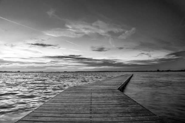 Romantic wall mural FP 1616 - A graphic design of a pier leading to water, surrounded by clouds.