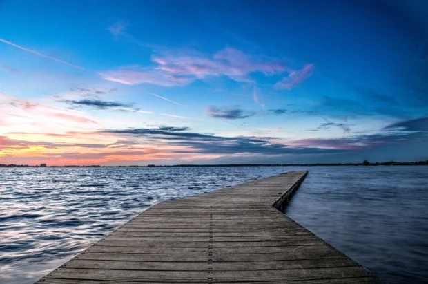 Romantic wall mural FP 1616 - A graphic design of a pier leading to water, surrounded by shades of sky.