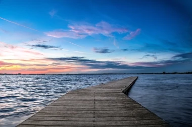 Romantic wall mural FP 1616 - A graphic design of a pier leading to water, surrounded by shades of sky.