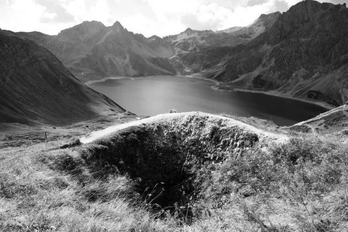 Wall mural featuring a picturesque lake in the mountains FP 1613 - Graphic design with visible mountains, lake, and grass.