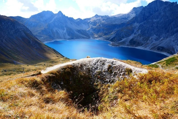 Wall mural featuring a picturesque lake in the mountains FP 1613 - Graphic design with mountains, lake, and grass.