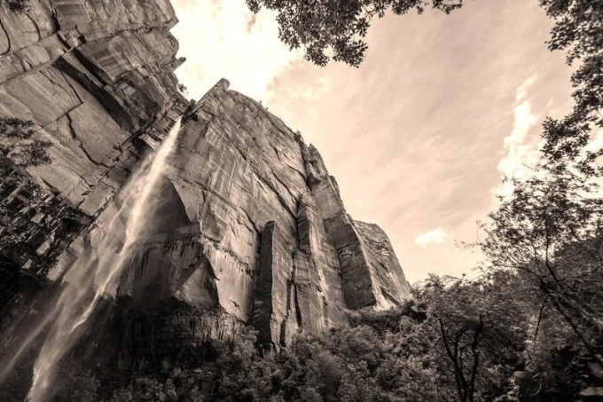 Waterfall wallpaper among red rocks FP 1622 - Graphic design. Water cascades down a high cliff, surrounded by nature.