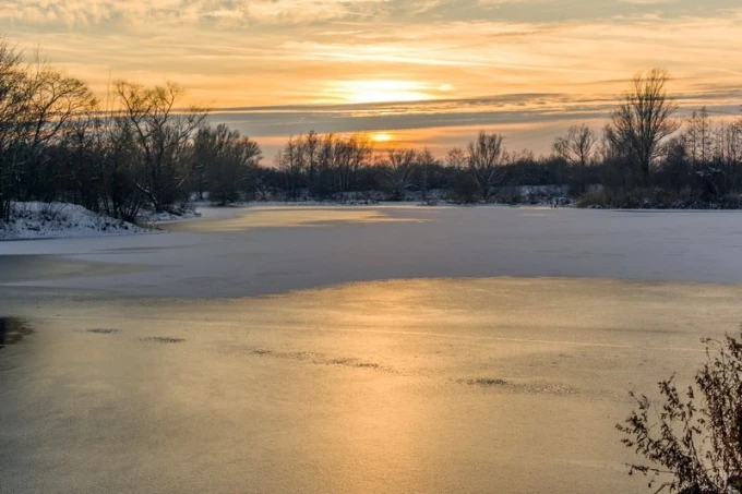 Wall mural of a sunset over a frozen lake FP 2016 - Graphic design. Sunset in warm hues.
