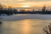 Wall mural of a sunset over a frozen lake FP 2016 - Graphic design. Sunset in warm hues.