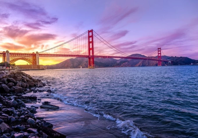Wall mural of a red suspension bridge over water, with mountains in the background. Design FP 2151.
