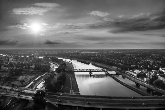 Wall mural sunset over the city FP 2258 - Graphic design. View of the city with a river and bridge.