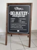 Chalkboard A-frame with custom print - Restaurant setup. Light-colored walls, tiled floor.