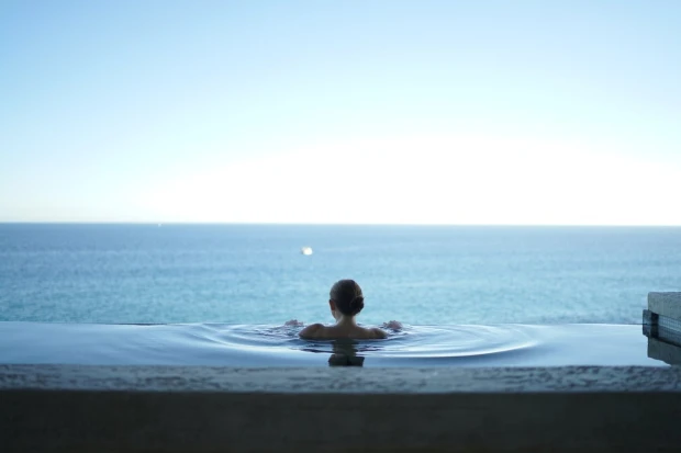 Wall mural of a woman in a pool FP 3150 - Decor with a sea view. Water reflects the sky.