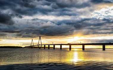 Wall mural of a bridge over a lake with clouds and rays of light, design FP 3413.