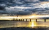 Wall mural of a bridge over a lake with clouds and rays of light, design FP 3413.