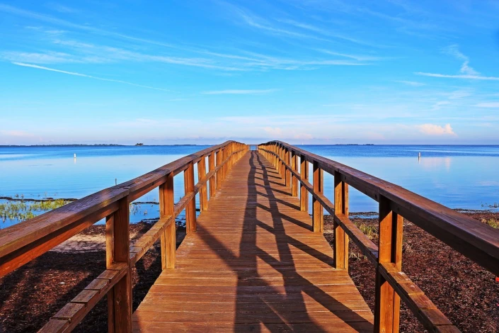 Coastal pier wallpaper FP 3535 - Graphic design. A wooden pier leads to the water, surrounded by the sky.