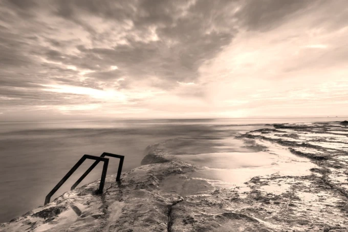 Wall mural of an extraordinary island FP 3787 - Graphic design featuring a beach with stones and stairs leading to the water.