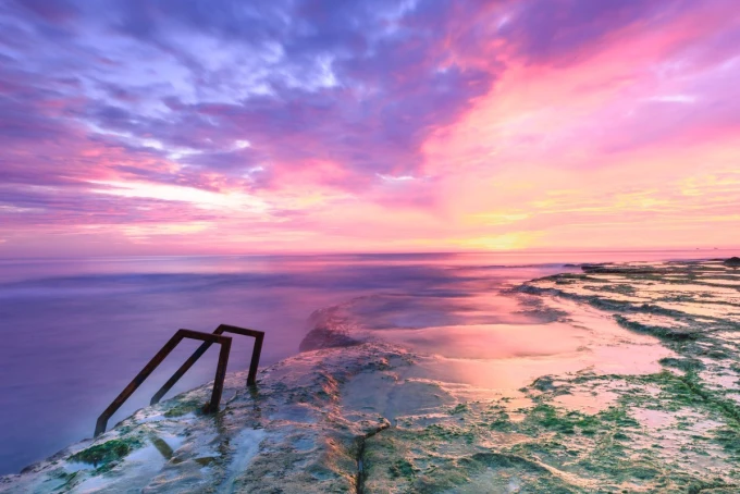 Wall mural extraordinary island FP 3787 - Graphic design featuring a landscape with sea and sky in shades of pink.