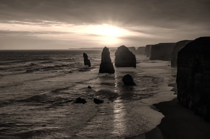 Wall mural summer sunset FP 4196 - Graphic design. The sun sets over the sea, with high cliffs and rocks in the background.