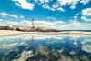 Wall mural of a lighthouse reflected in water FP 4439 - Graphic design featuring a lighthouse against a cloudy sky.