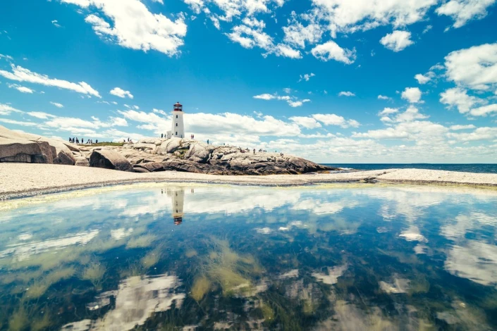 Wall mural of a lighthouse reflected in water FP 4439 - Graphic design featuring a lighthouse against a cloudy sky.