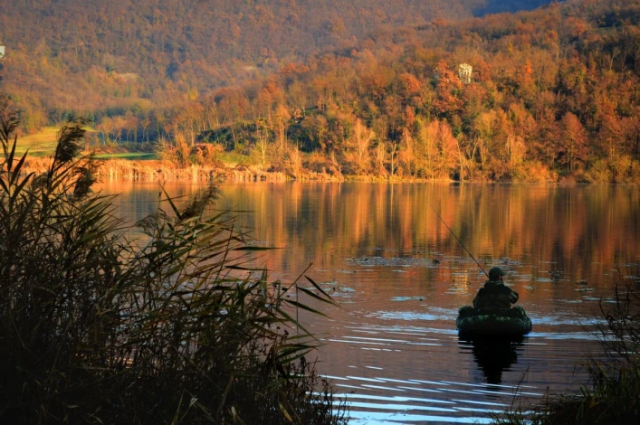 Wall mural of a fisherman on an autumn lake FP 4517 - Living room decor in warm shades of brown and green.