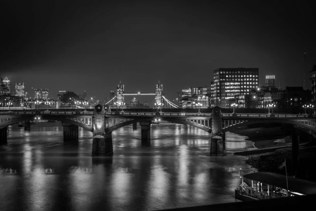 Wall mural of a bridge illuminated by colorful lights at night, with reflections in the water. Design FP 4618.
