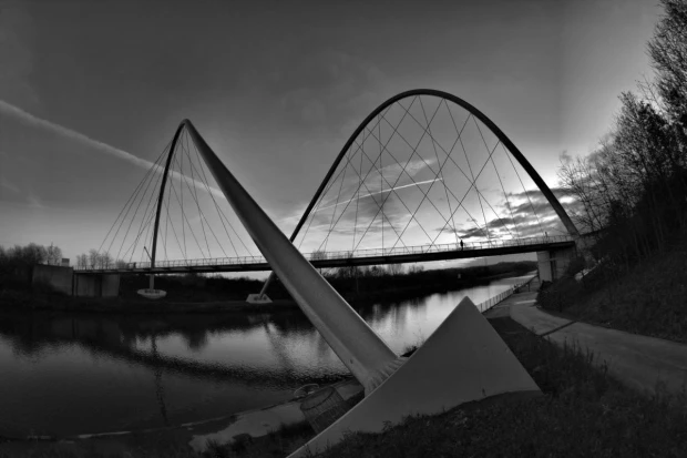 Wall mural of a solitary man on a modern bridge FP 4978 - Graphic design. Bridge with large arches and reflections.