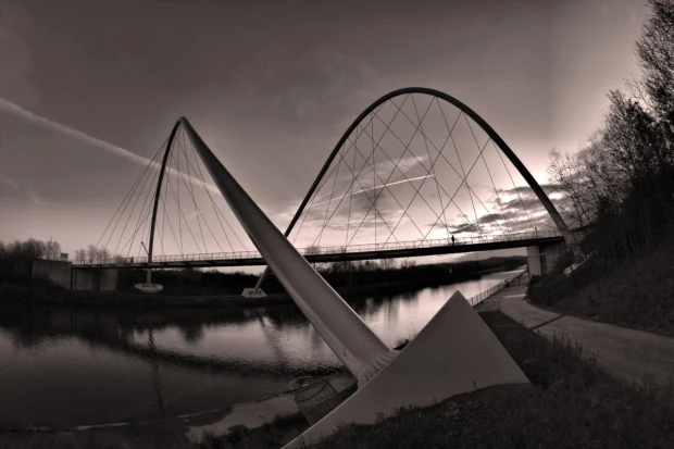 Wall mural of a solitary man on a modern bridge FP 4978 - Graphic design. Bridge with large arches over water.
