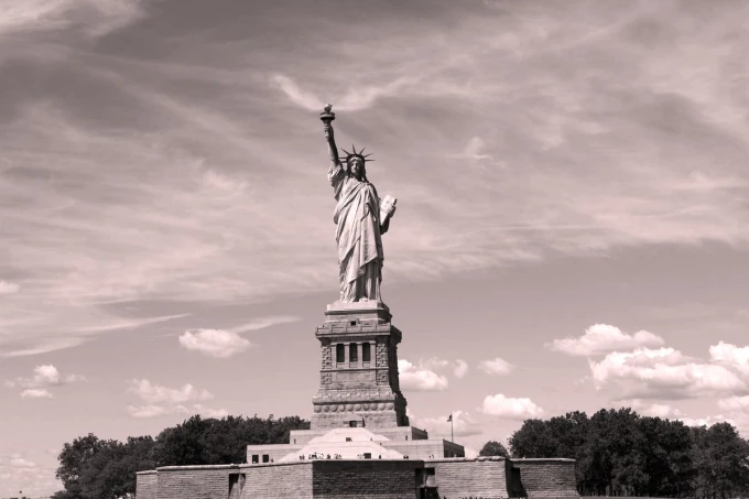 Wall mural of the historic Statue of Liberty FP 5536 - Graphic design. Statue with raised torch against a cloudy backdrop.