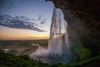Wall mural waterfall sunset FP 5651 - Graphic design. Water cascades from a cliff with a sunset and greenery in the background.