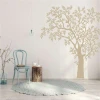 Tree wall stencil 2381 - Living room decor. Light walls, wooden furniture, round rug.