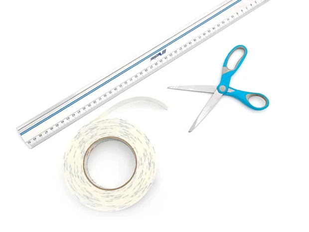 Oracal 10 mm foam mounting tape with graphic design, rolled with scissors and ruler beside it.