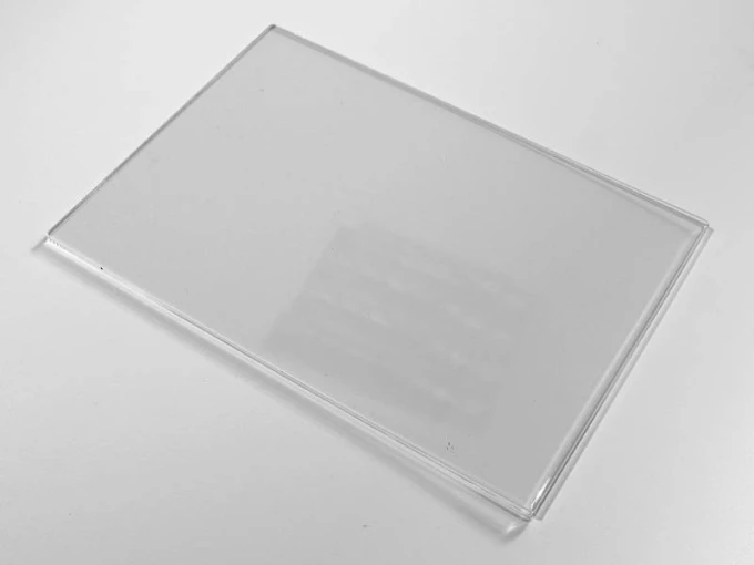 A4 plexiglass shirt - Graphic design. Rectangular, transparent shape with smooth edges.