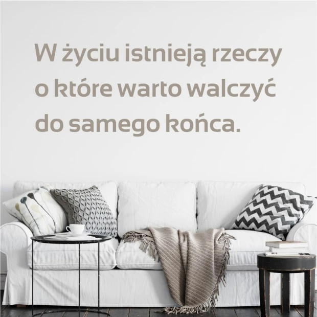 Wall template with the quote: In life, there are things 1973 - Living room arrangement. Light walls, sofa with various cushions.