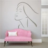 Woman\'s face wall template 2032 - Living room decor. Light-colored walls, pink sofa with a white cushion.