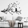 Wall sticker of a cat on a branch 2382 - Living room decor with light-colored walls and gray furniture.