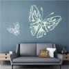 Butterfly wall sticker 2362 - Living room setup with a blue wall and a gray sofa with cushions.