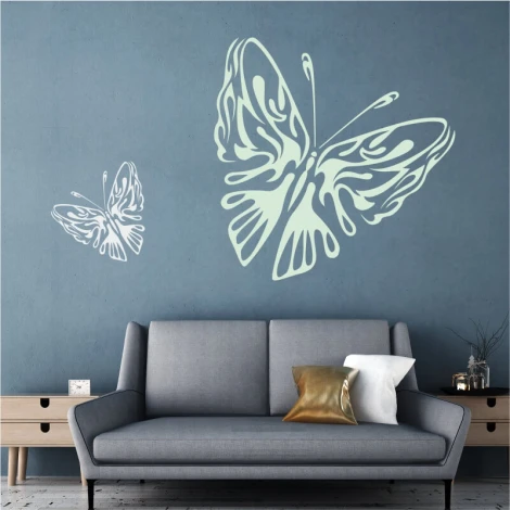 Butterfly wall sticker 2362 - Living room setup with a blue wall and a gray sofa with cushions.